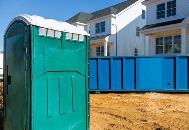 a row of porta potties on a bustling work site